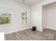 Bright, empty room with two windows, wood-look flooring, white walls and trim at 941 Rachel Anne Dr, Belmont, NC 28012