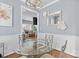 Bright dining room with a modern chandelier and a clear view into the adjacent living room at 9775 Mallard Glen Dr, Charlotte, NC 28262