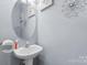 Stylish powder room with a sleek oval mirror and modern fixtures complements the home's sophisticated design at 9775 Mallard Glen Dr, Charlotte, NC 28262