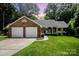 Charming brick home featuring a well-manicured lawn, attached garage, and cozy front porch at 1014 Covewood Ct, Charlotte, NC 28270