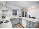 Well-lit kitchen featuring gray lower cabinets, white upper cabinets, and sliding glass doors to the backyard at 1014 Covewood Ct, Charlotte, NC 28270