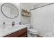 Bathroom featuring a vanity, a round mirror, and a white shower curtain at 1016 Spanish Moss Rd, Indian Trail, NC 28079