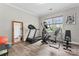 Well-lit exercise room equipped with a treadmill and other fitness equipment on hardwood floors at 1016 Spanish Moss Rd, Indian Trail, NC 28079