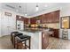 Stylish kitchen featuring dark wood cabinetry, a granite countertop island with seating, and modern stainless-steel appliances at 1016 Spanish Moss Rd, Indian Trail, NC 28079