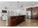 Spacious kitchen island with granite countertop and stainless steel appliances blends into the living space at 1016 Spanish Moss Rd, Indian Trail, NC 28079