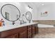 Bathroom boasts dual sinks, garden tub, with white countertop, and dark wood cabinets at 1016 Spanish Moss Rd, Indian Trail, NC 28079