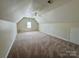 An attic with neutral carpeting, a ceiling fan, and a window at 1043 Cambrook Ct, Concord, NC 28027