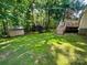 A backyard with a shed, a deck, and green grass and many trees at 1043 Cambrook Ct, Concord, NC 28027