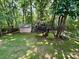 A backyard with a shed, trees, and green grass at 1043 Cambrook Ct, Concord, NC 28027