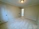A spacious bedroom featuring neutral carpeting, a ceiling light, and a doorway leading to another room at 1043 Cambrook Ct, Concord, NC 28027