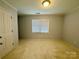 A bedroom featuring neutral carpeting, a ceiling light, and a window with horizontal blinds at 1043 Cambrook Ct, Concord, NC 28027