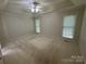Spacious bedroom featuring plush carpeting, tray ceilings, a ceiling fan, and natural light from two large windows at 1043 Cambrook Ct, Concord, NC 28027