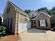 Beautiful brick home showcasing a two-car garage, basketball hoop, and well-maintained lawn at 1043 Cambrook Ct, Concord, NC 28027