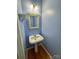 Stylish half-bathroom with a pedestal sink, uniquely decorated mirror, and charming blue walls at 1043 Cambrook Ct, Concord, NC 28027