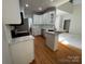 Open-concept kitchen with a breakfast bar, white cabinetry, stainless appliances, and hardwood flooring at 1043 Cambrook Ct, Concord, NC 28027