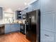 Well-lit kitchen with blue cabinets, granite countertops, and sleek black appliances offers style at 10743 Ola Dr, Fort Mill, SC 29707