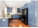 Spacious kitchen with blue cabinets, stainless steel sink, and modern black appliances for cooking at 10743 Ola Dr, Fort Mill, SC 29707