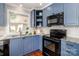 Efficient kitchen features blue cabinets, granite counters, and modern appliances for cooking convenience at 10743 Ola Dr, Fort Mill, SC 29707