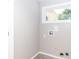 The clean laundry room features tile flooring, a bright window, and accessible hookups at 10743 Ola Dr, Fort Mill, SC 29707