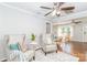 Bright living room featuring hardwood floors, ceiling fan, neutral paint, area rug and two cushioned chairs at 10743 Ola Dr, Fort Mill, SC 29707