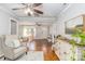 Bright living room with hardwood floors, ceiling fan, neutral paint, fireplace, cushioned chairs, and area rug at 10743 Ola Dr, Fort Mill, SC 29707