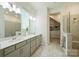 Luxurious bathroom featuring a double vanity, walk-in shower, and custom closet at 1133 Idyllic Ln, Waxhaw, NC 28173