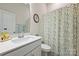 Bright bathroom featuring a white vanity, floral shower curtain and decorated with a flower picture frame at 1133 Idyllic Ln, Waxhaw, NC 28173