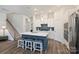 Open-concept kitchen features a large center island, white cabinetry, and hardwood floors, seamlessly connecting to the living spaces at 1133 Idyllic Ln, Waxhaw, NC 28173