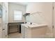 Bright laundry room with granite countertops, appliances and a metal rack for hanging clothes at 1133 Idyllic Ln, Waxhaw, NC 28173
