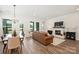 Cozy living room with a brick fireplace, ample natural light, a leather sofa, and hardwood floors at 1133 Idyllic Ln, Waxhaw, NC 28173