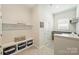 All-white mudroom features a bench with storage, coat hooks, and access to the laundry room at 1133 Idyllic Ln, Waxhaw, NC 28173