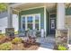 Close up of a charming front porch with cozy wicker chairs, and stone pillars at 1133 Idyllic Ln, Waxhaw, NC 28173