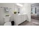 Bright bathroom with double vanity, stylish fixtures, wood-look flooring, and view into bedroom at 117 Lanyard Dr # E, Mooresville, NC 28117