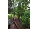 Scenic backyard view from the deck overlooking green foliage and a brick fence at 1253 Iverleigh Trl, Charlotte, NC 28270
