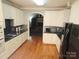 Bright kitchen features white cabinets, granite countertops, tile backsplash, and hardwood flooring at 1253 Iverleigh Trl, Charlotte, NC 28270