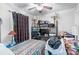 Bedroom with ceiling fan, bedside lamps, TV, and black metal shelving unit at 1315 Cortland E Rd, Charlotte, NC 28209