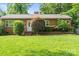 Charming single-story brick home with a well-manicured lawn and mature landscaping at 1315 Cortland E Rd, Charlotte, NC 28209
