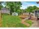 Expansive backyard featuring a wooden deck with access ramp, shed, and mature trees, perfect for outdoor activities at 1405 8Th Nw Ave, Conover, NC 28613