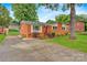 Charming brick home with a red door, landscaped yard, and long concrete driveway at 1405 8Th Nw Ave, Conover, NC 28613