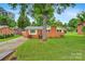 Charming brick home with well-maintained lawn, mature tree, and red front door, exuding curb appeal at 1405 8Th Nw Ave, Conover, NC 28613