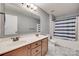 Bathroom with double vanity, bronze fixtures, and shower with blue striped curtain at 1412 Afternoon Sun Rd, Matthews, NC 28104