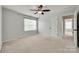 Spacious bedroom with neutral tones, fan, large window, and entry to another room at 1412 Afternoon Sun Rd, Matthews, NC 28104
