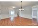 Light-filled dining room with hardwood floors, modern chandelier, and wainscoting at 1412 Afternoon Sun Rd, Matthews, NC 28104