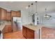 Kitchen with stainless steel appliances, a granite island, wood floors, and pendant lights at 1412 Afternoon Sun Rd, Matthews, NC 28104