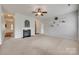 Cozy living room showcasing a fireplace, neutral walls, built-in shelves, and plush carpet at 1412 Afternoon Sun Rd, Matthews, NC 28104