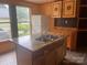 Kitchen island with a stainless steel sink, accompanied by a refrigerator and unique cabinets at 1418 Old Wilkesboro Rd, Salisbury, NC 28144