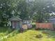 Unique backyard shed featuring whimsical art and colorful mosaic tiles, set amongst lush greenery at 1418 Old Wilkesboro Rd, Salisbury, NC 28144