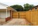 View of backyard with wooden fence and gate leading to the garage of this charming home at 1421 Thompson Ave, Charlotte, NC 28216