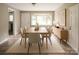 Bright dining room featuring a wooden table, beige chairs, and large windows providing ample natural light at 1421 Thompson Ave, Charlotte, NC 28216
