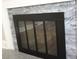 A close up of a modern fireplace with stone surround and black door at 1421 Thompson Ave, Charlotte, NC 28216